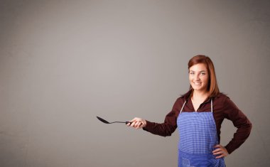 Güzel bir kadın kaşık tutuyor.