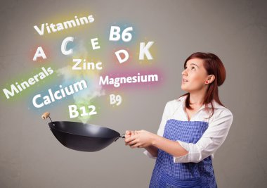 Genç bir kadın vitamin ve mineral pişiriyor.