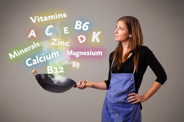 Genç bir kadın vitamin ve mineral pişiriyor.