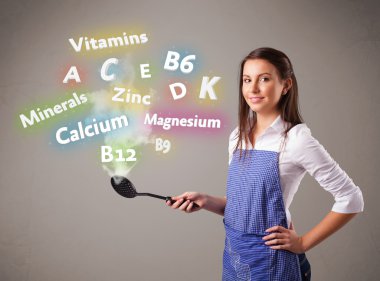 Genç bir kadın vitamin ve mineral pişiriyor.