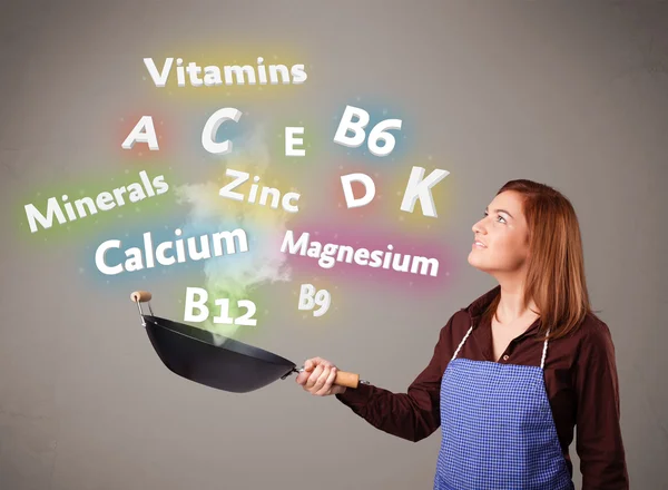 Young woman cooking vitamins and minerals — Stock Photo, Image