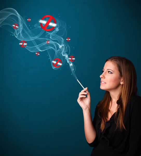 Young woman smoking dangerous cigarette with no smoking signs — Stock Photo, Image