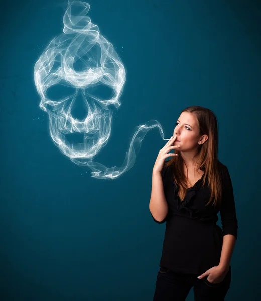 Young woman smoking dangerous cigarette with toxic skull smoke — Stock Photo, Image