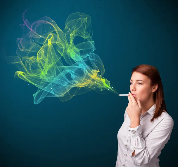 Pretty lady smoking cigarette with colorful smoke — Stock Photo, Image