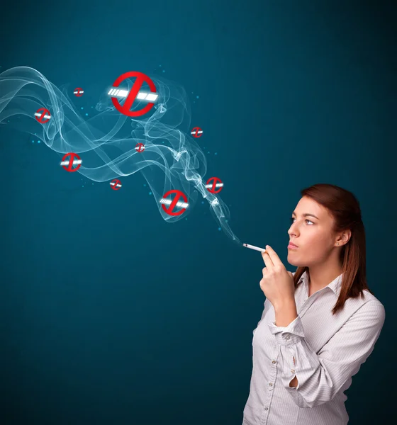 Young woman smoking dangerous cigarette with no smoking signs — Stock Photo, Image