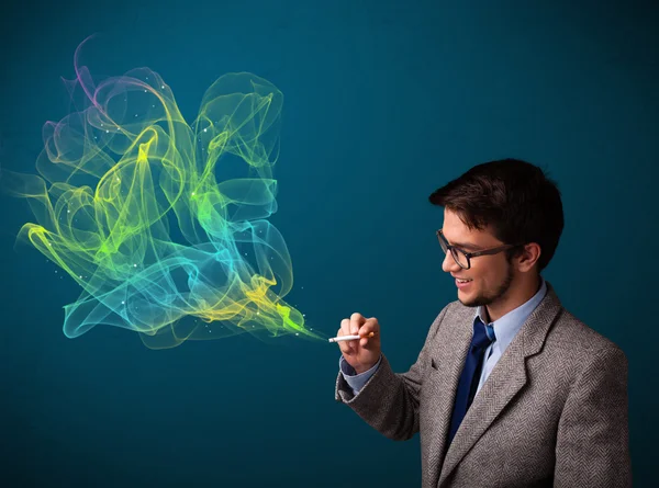 Bel homme fumant cigarette avec de la fumée colorée — Photo