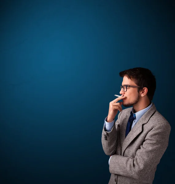 Young man smoking cigarette with copy space — Stock Photo, Image