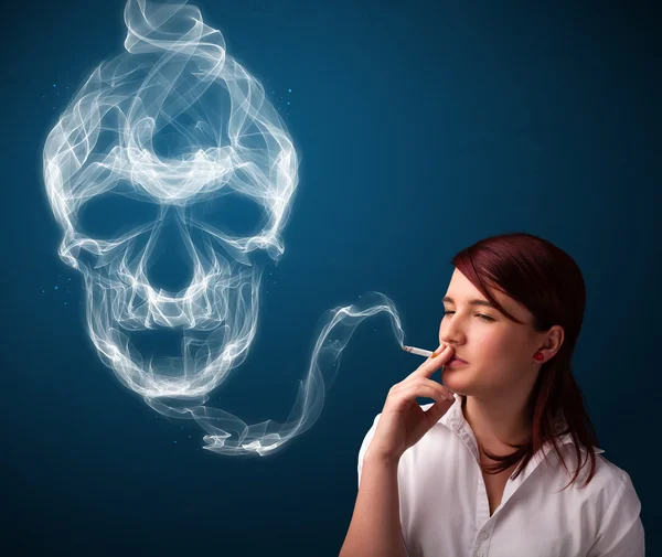 Mujer joven fumando peligroso cigarrillo con humo de cráneo tóxico —  Fotos de Stock