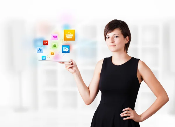 Junge Frau blickt auf modernes Tablet mit bunten Symbolen — Stockfoto