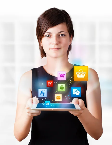 Junge Frau blickt auf modernes Tablet mit bunten Symbolen — Stockfoto