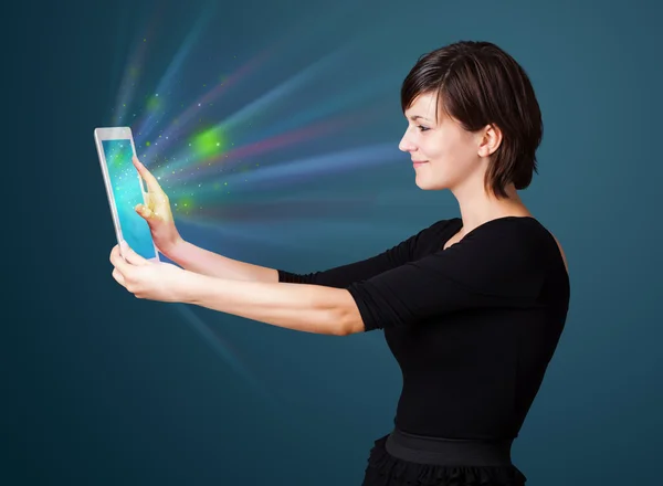 年轻女子用抽象的光看现代平板电脑 — 图库照片