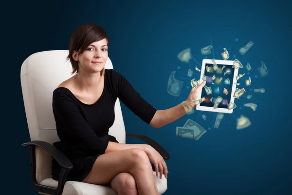 Young woman holding tablet with money — Stock Photo, Image