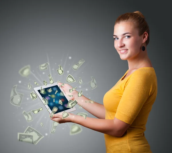 Mladá žena držení tabletu s penězi — Stock fotografie