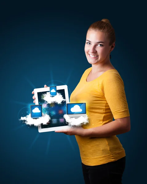 Bulutlarda modern aletlerle tablet tutan genç bir kadın. — Stok fotoğraf