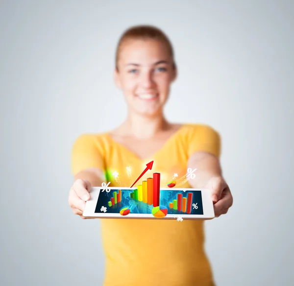 Mujer joven sosteniendo la tableta con gráficos y diagramas de colores — Foto de Stock