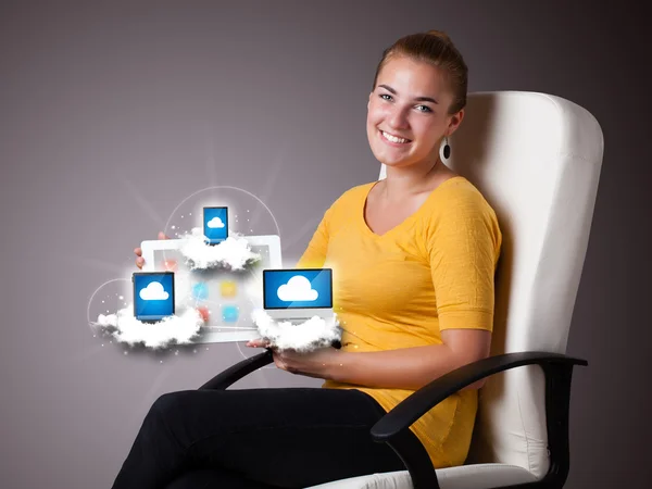 Młoda kobieta trzyma tablet z nowoczesnymi urządzeniami w chmurach — Zdjęcie stockowe