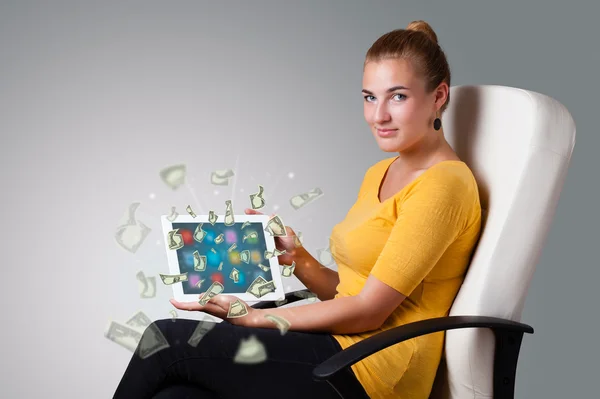 Молодая женщина держит планшет с деньгами — стоковое фото