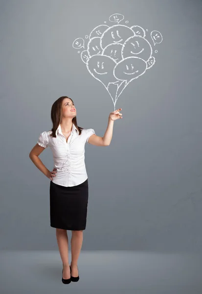 Mujer feliz sosteniendo globos sonrientes dibujo — Foto de Stock