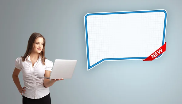 Young woman holding a laptop and presenting modern speech bubble — Stock Photo, Image