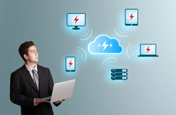 Young man holding a laptop and presenting cloud computing networ — Stock Photo, Image