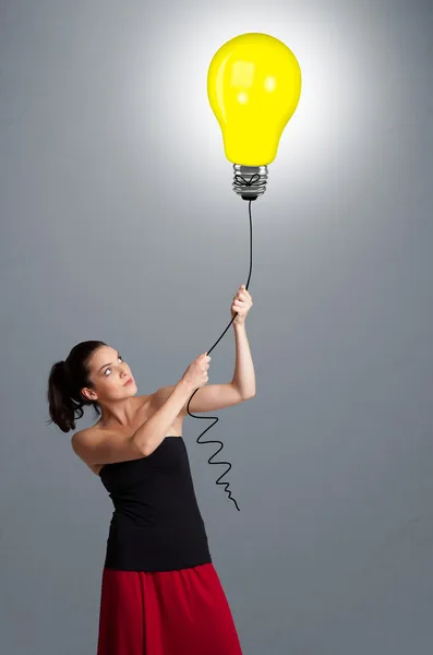Pretty lady holding a light bulb balloon — Stock Photo, Image