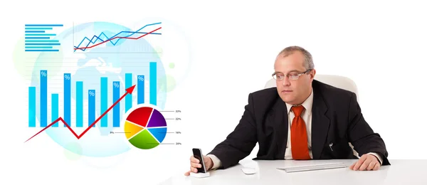 Podnikatel sedí u stolu s statistiky — Stock fotografie
