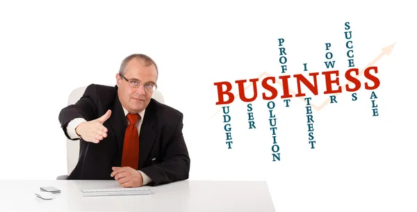 Businesman sitting at desk with business word cloud — Stockfoto