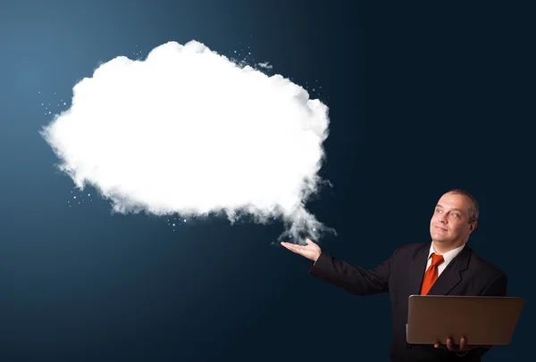 Businessman holding a laptop and presenting abstract cloud copy — Stock Photo, Image