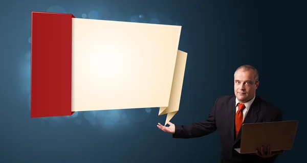 Empresario sosteniendo un portátil y presentando una copia moderna en origami —  Fotos de Stock