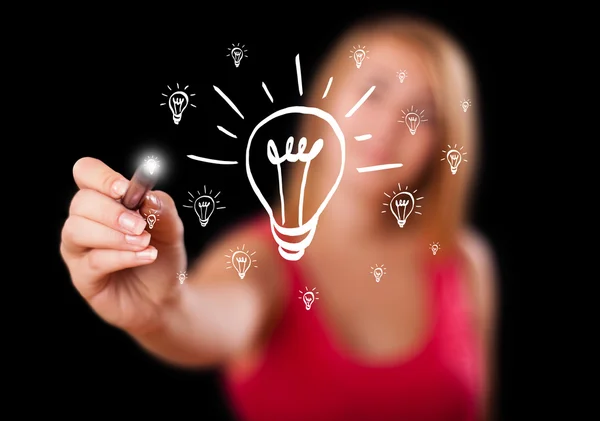 Woman drawing light bulb on whiteboard — Stock Photo, Image