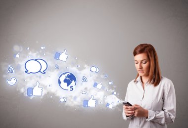 Sosyal medya simgeleriyle telefon tutan güzel bir genç kız.