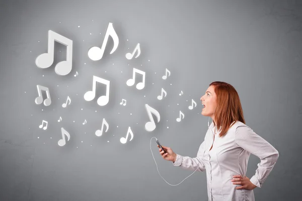 Jolie jeune femme chantant et écoutant de la musique avec n musical — Photo