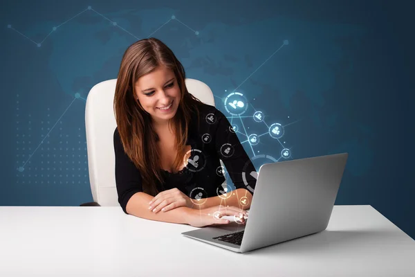 Jonge dame zit aan Bureau en typen op laptop met sociale netw — Stockfoto