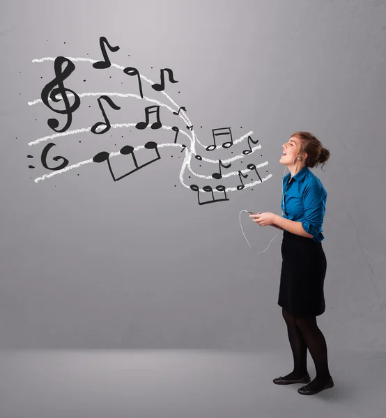 Attraktive junge Frau, die mit musica singt und Musik hört — Stockfoto