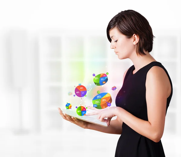 Jovem mulher olhando para tablet moderno com gráficos de torta — Fotografia de Stock