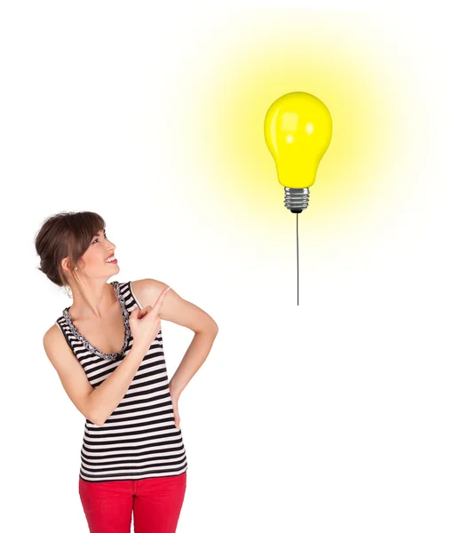 Happy woman holding a light bulb balloon — Stock Photo, Image