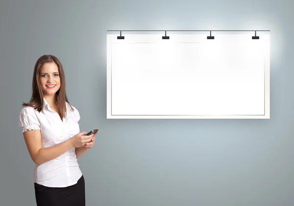 Young woman standing next to a modern copy space and holding a p — Stock Photo, Image