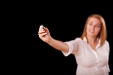 Genç bir kadın tahtaya resim çiziyor.