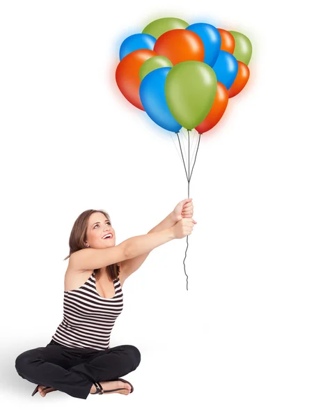 Ung kvinna som håller färgglada ballonger — Stockfoto