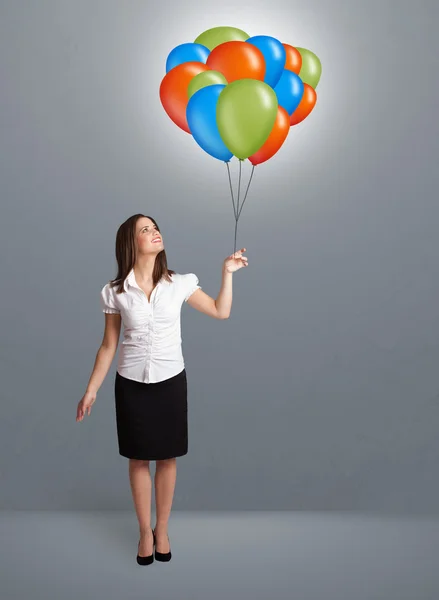 Jeune femme tenant des ballons colorés — Photo