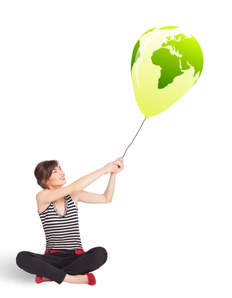 Happy lady holding a green globe balloon — Stock Photo, Image