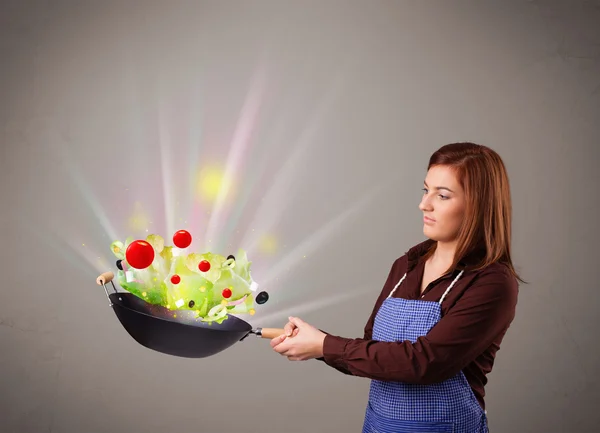 Mujer joven cocinando verduras frescas — Foto de Stock