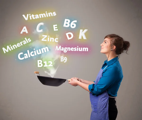 Young woman cooking vitamins and minerals — Stock Photo, Image