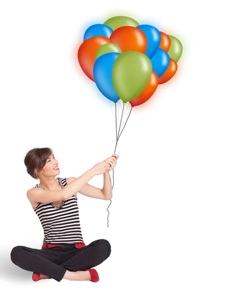 Mujer joven sosteniendo globos de colores — Foto de Stock