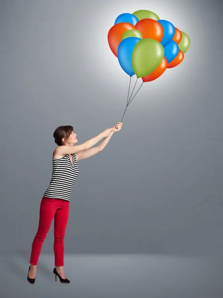 Młoda kobieta trzyma kolorowe balony — Zdjęcie stockowe