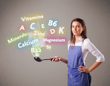 Genç bir kadın vitamin ve mineral pişiriyor.