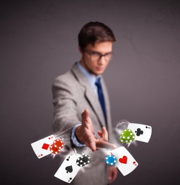 Poker kartları ve fişlerle oynayan genç adam.