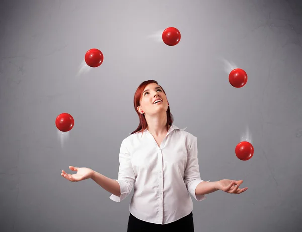 Mladá dívka stojící a žonglování s červenými kuličkami — Stock fotografie