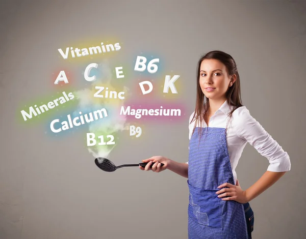 Young woman cooking vitamins and minerals — Stock Photo, Image