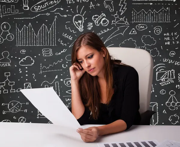 Mujer de negocios sentada en el escritorio con esquema de negocios e iconos —  Fotos de Stock